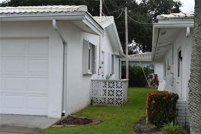 view of property exterior featuring a lawn and a garage