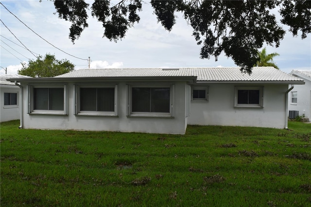 back of property featuring a yard and central air condition unit