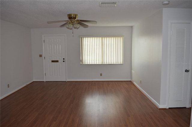 unfurnished room with a textured ceiling, ceiling fan, and dark hardwood / wood-style flooring