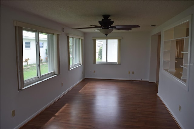 empty room featuring a textured ceiling, dark wood-type flooring, and ceiling fan