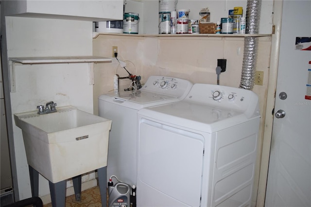 clothes washing area featuring washer and clothes dryer and sink