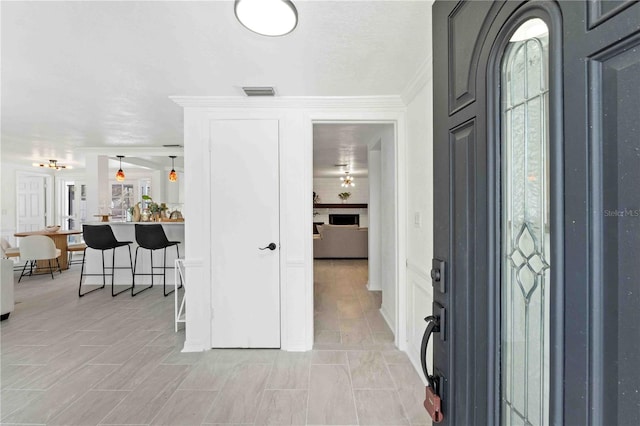 foyer entrance with ornamental molding and a healthy amount of sunlight