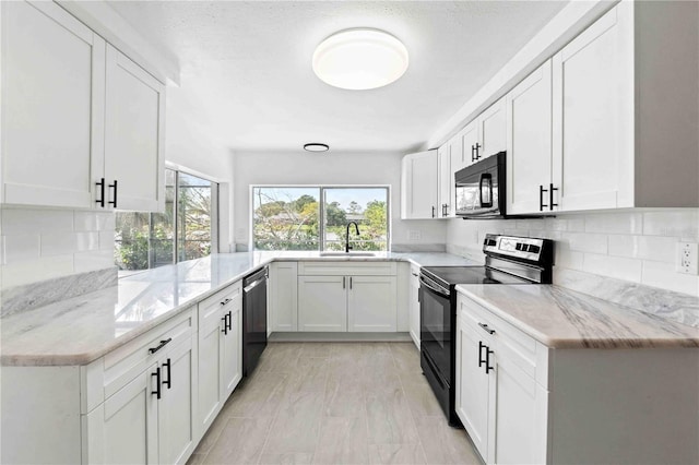 kitchen with white cabinets, sink, black appliances, and light stone counters