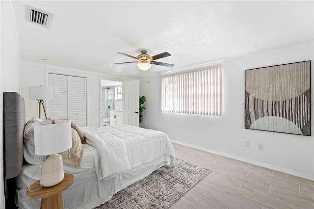 bedroom featuring ornamental molding, a closet, ceiling fan, and ensuite bath