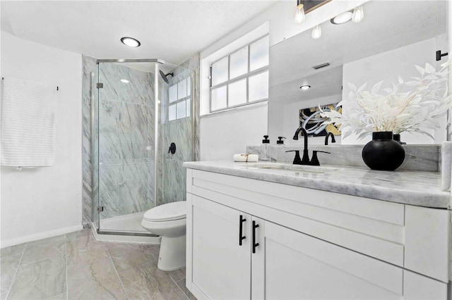 bathroom with a shower with shower door, vanity, and toilet