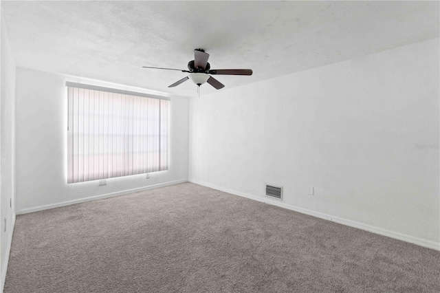 carpeted spare room with ceiling fan