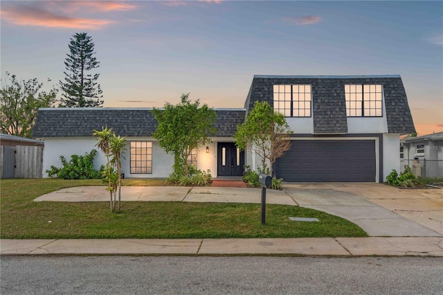 view of front of house with a garage and a yard