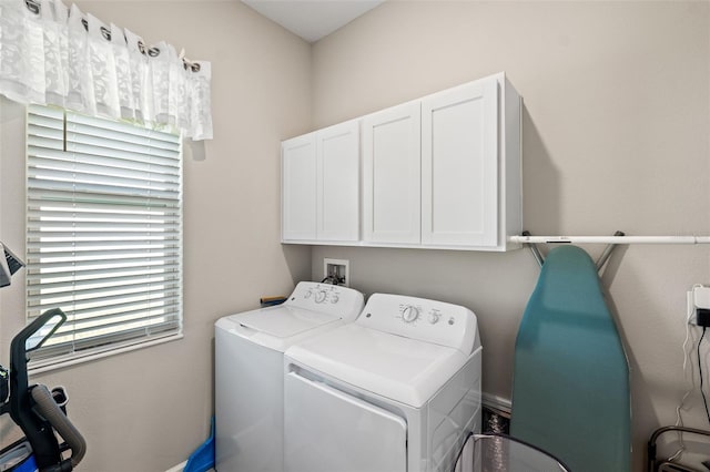 laundry area with independent washer and dryer and cabinets