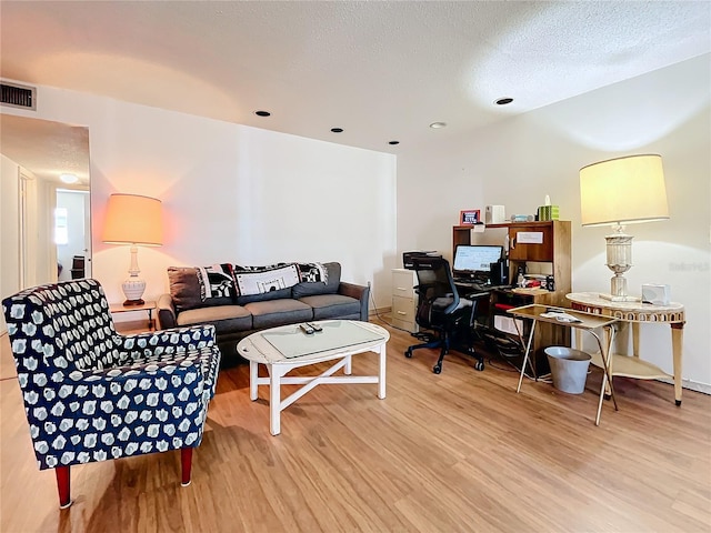 living room with wood-type flooring and a textured ceiling