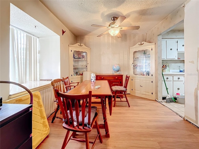 dining room featuring a textured ceiling, wood-type flooring, and ceiling fan