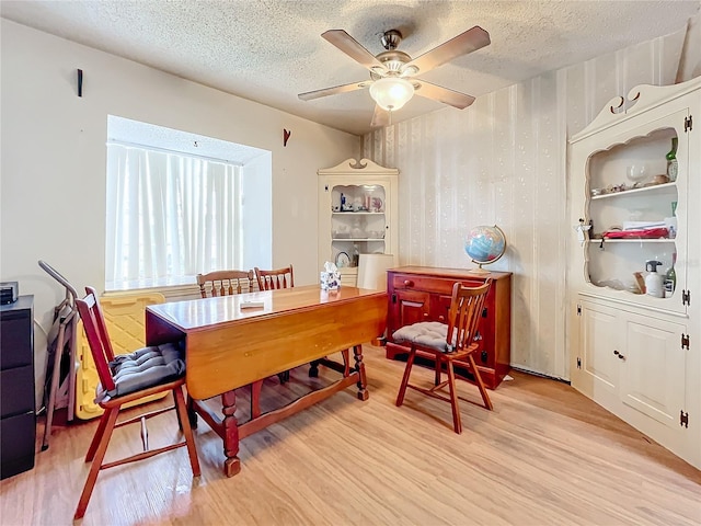 dining space featuring a textured ceiling, light hardwood / wood-style floors, and ceiling fan