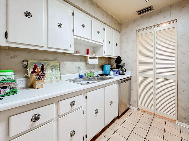 kitchen featuring white cabinets, light tile patterned flooring, sink, and stainless steel dishwasher