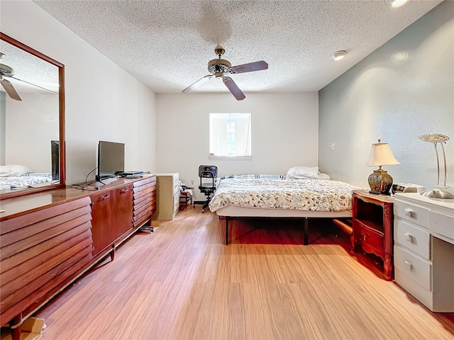 bedroom with ceiling fan, a textured ceiling, and light wood-type flooring