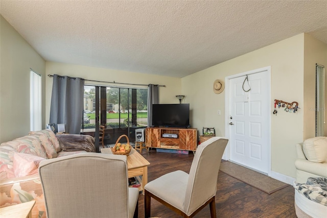 living room featuring dark hardwood / wood-style flooring and a textured ceiling