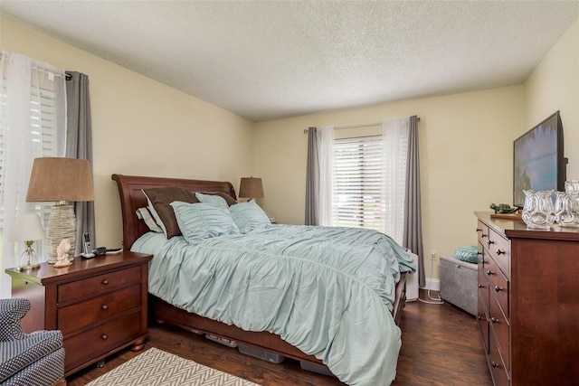 bedroom with dark hardwood / wood-style floors and a textured ceiling