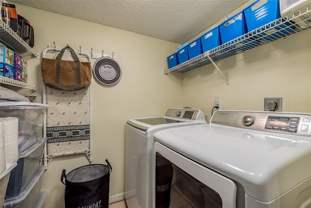 clothes washing area featuring washer and dryer and a textured ceiling