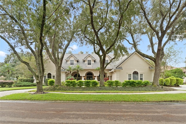 view of front facade with a tile roof and stucco siding