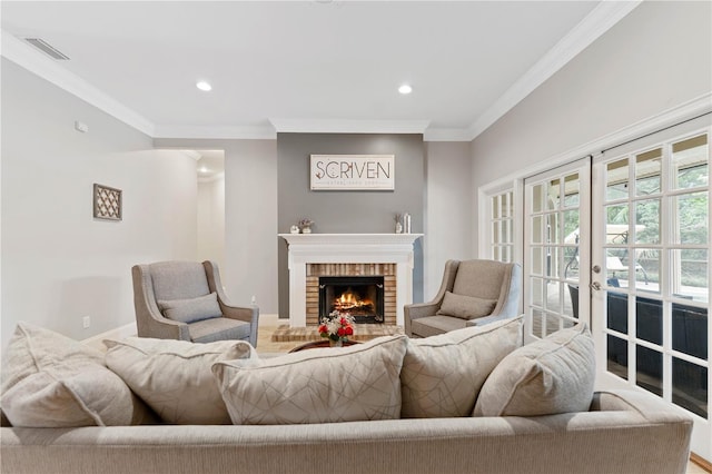 living area with french doors, recessed lighting, visible vents, ornamental molding, and a brick fireplace