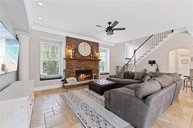 living room with baseboards, crown molding, stone tile flooring, a fireplace, and recessed lighting