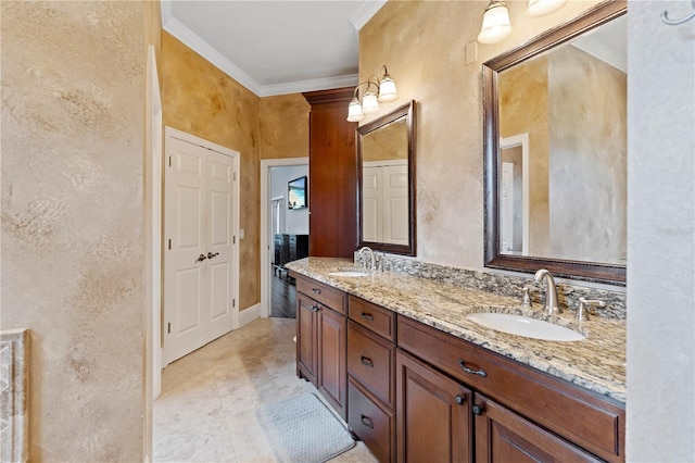 bathroom featuring a textured wall, double vanity, a sink, and crown molding