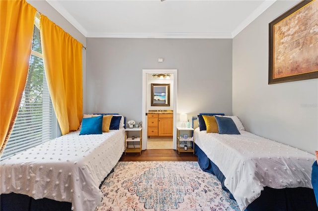 bedroom with ensuite bath, wood finished floors, and crown molding