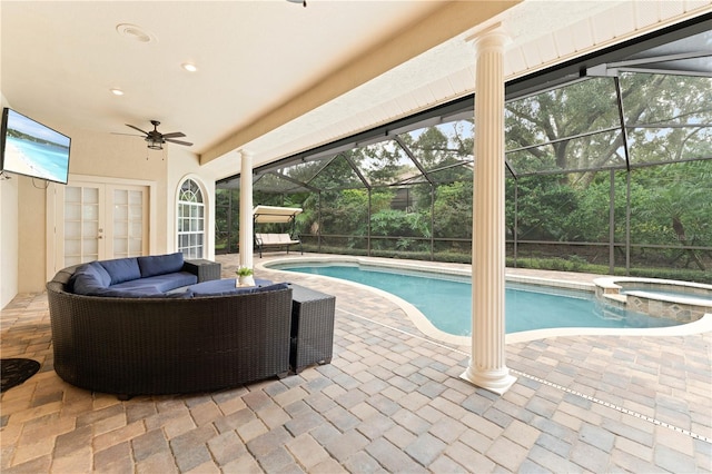 view of pool with ceiling fan, a lanai, a patio area, a pool with connected hot tub, and outdoor lounge area