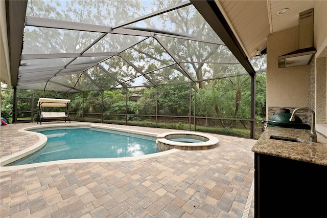 view of swimming pool with a lanai, a patio area, and a sink