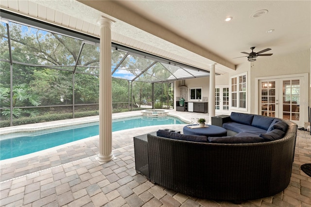 view of pool with french doors, outdoor lounge area, a ceiling fan, glass enclosure, and a patio area