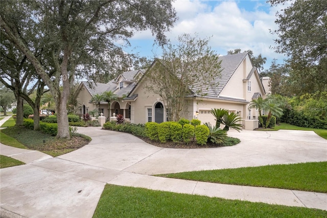 view of front of home featuring a garage, concrete driveway, and stucco siding