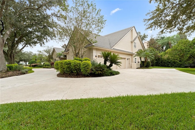 view of side of home with driveway, a lawn, an attached garage, and stucco siding