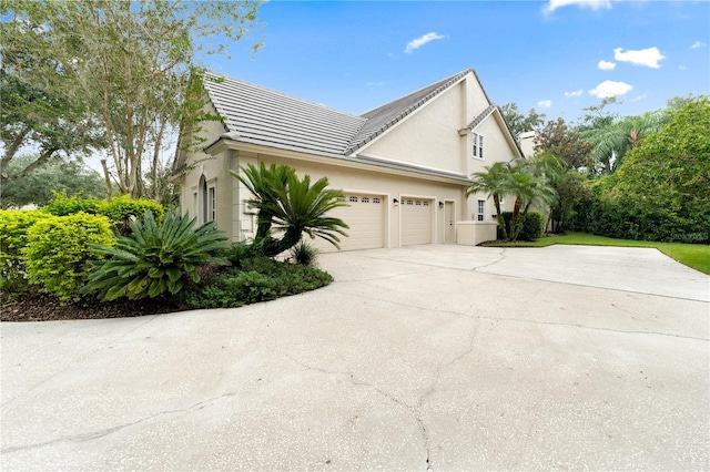 view of property exterior with concrete driveway, an attached garage, and stucco siding