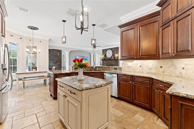 kitchen featuring a peninsula, a sink, visible vents, appliances with stainless steel finishes, and stone tile flooring