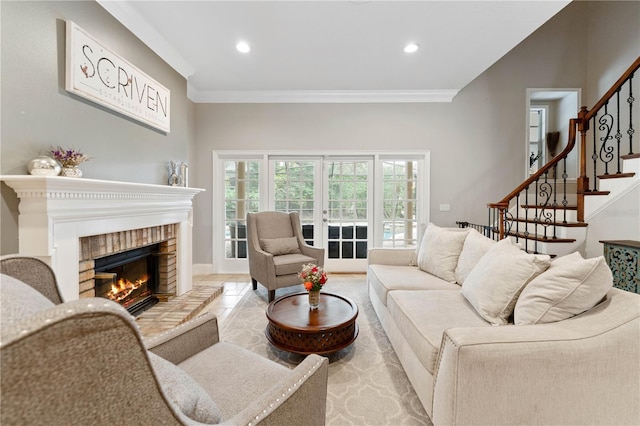 living room featuring ornamental molding, stairs, french doors, a brick fireplace, and recessed lighting