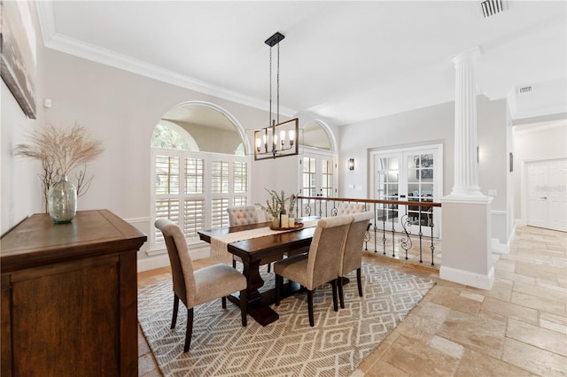 dining space with ornamental molding, stone tile flooring, decorative columns, and french doors