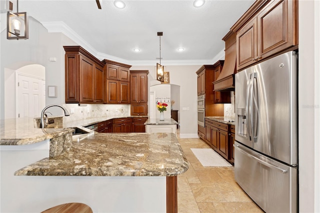 kitchen with a peninsula, appliances with stainless steel finishes, a sink, and decorative backsplash