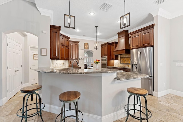 kitchen with arched walkways, stainless steel appliances, a breakfast bar, visible vents, and custom exhaust hood