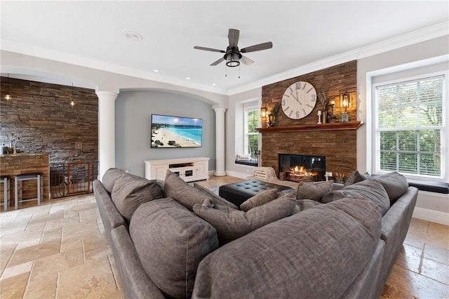 living room with a wealth of natural light, a fireplace, stone tile flooring, and baseboards