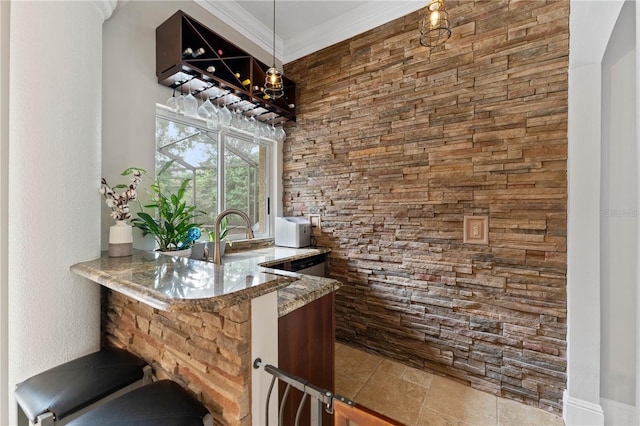 bar featuring pendant lighting, stone tile floors, and crown molding