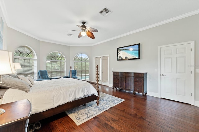 bedroom with wood-type flooring, visible vents, crown molding, and baseboards