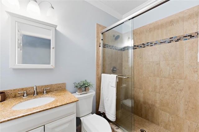 bathroom with a stall shower, vanity, and toilet