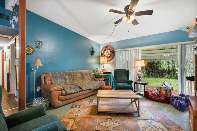 living area featuring lofted ceiling, carpet floors, and a ceiling fan