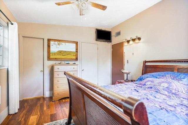 bedroom featuring baseboards, visible vents, ceiling fan, and wood finished floors