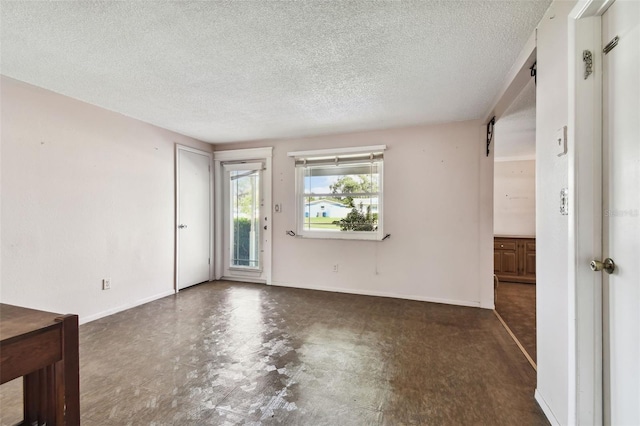 unfurnished room with a textured ceiling and a barn door