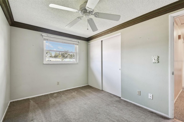 unfurnished bedroom with a textured ceiling, ceiling fan, carpet flooring, and crown molding