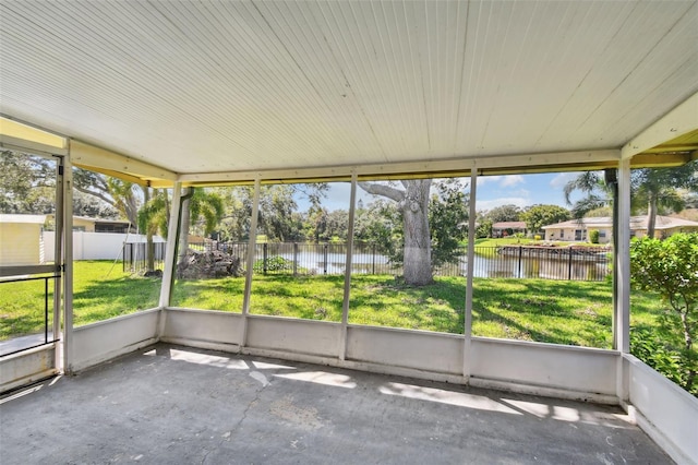 unfurnished sunroom featuring a water view