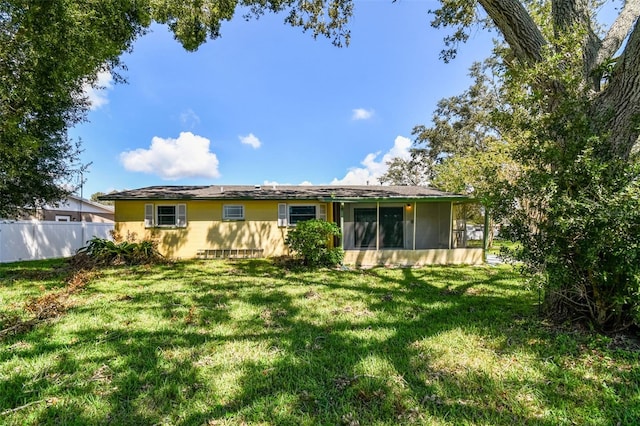 back of property featuring a sunroom and a yard