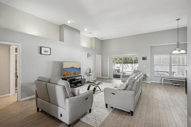 living room with a high ceiling and light hardwood / wood-style floors