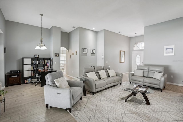 living room with a notable chandelier, light hardwood / wood-style floors, and plenty of natural light