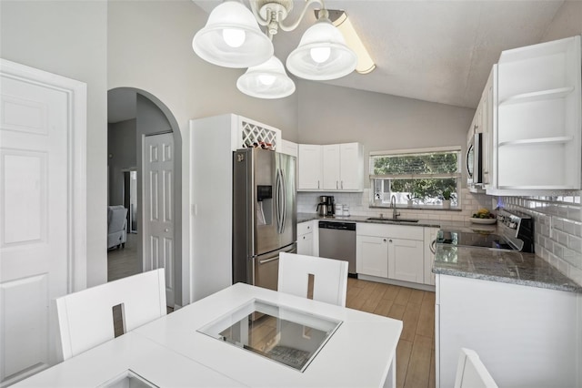 kitchen featuring sink, white cabinets, hanging light fixtures, light hardwood / wood-style flooring, and appliances with stainless steel finishes