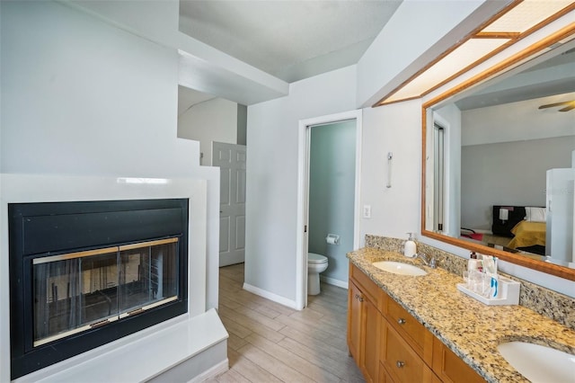 bathroom featuring vanity, toilet, ceiling fan, and hardwood / wood-style flooring